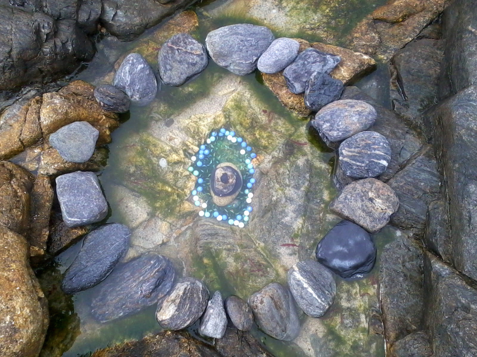 Intervención con piedras y canicas en la playa, en Faro Lariño.